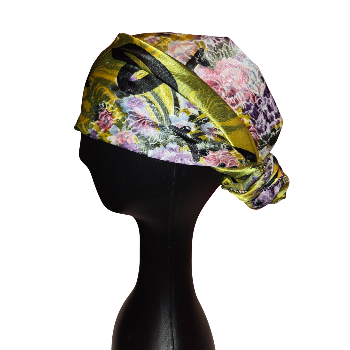 Colorful headscarf with floral and bird pattern on a mannequin head against a white background
