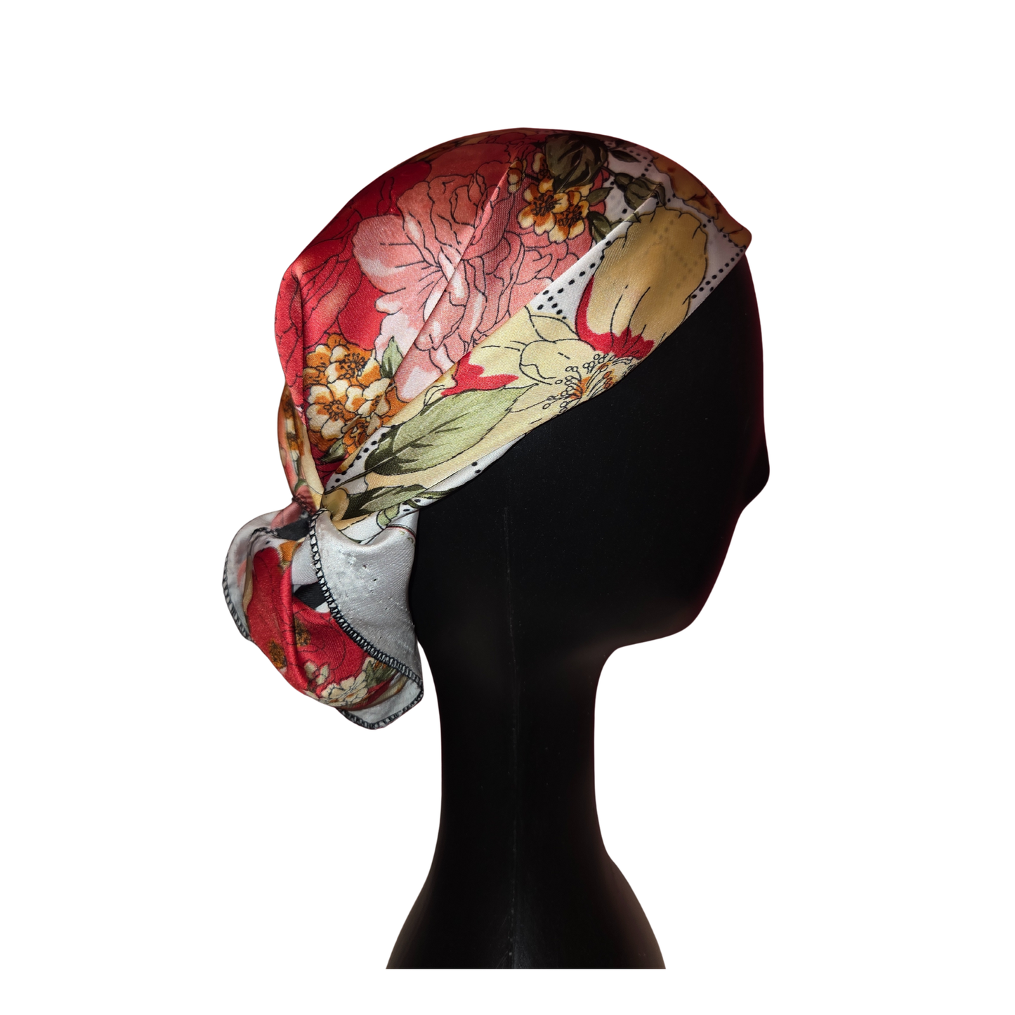 Colorful floral headscarf on a black mannequin head against a white background
