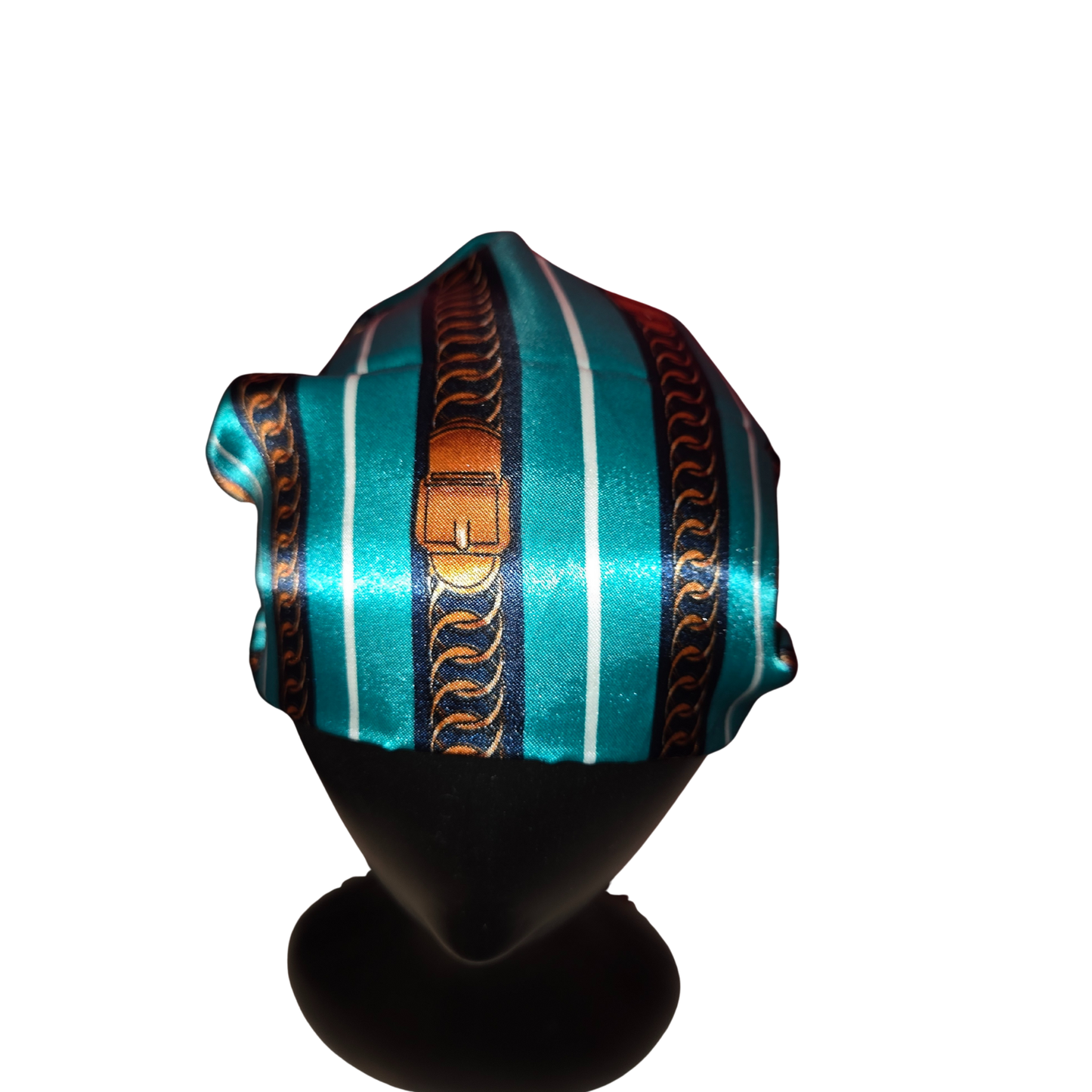 Turquoise headwrap with decorative patterns on a mannequin head against a white background
