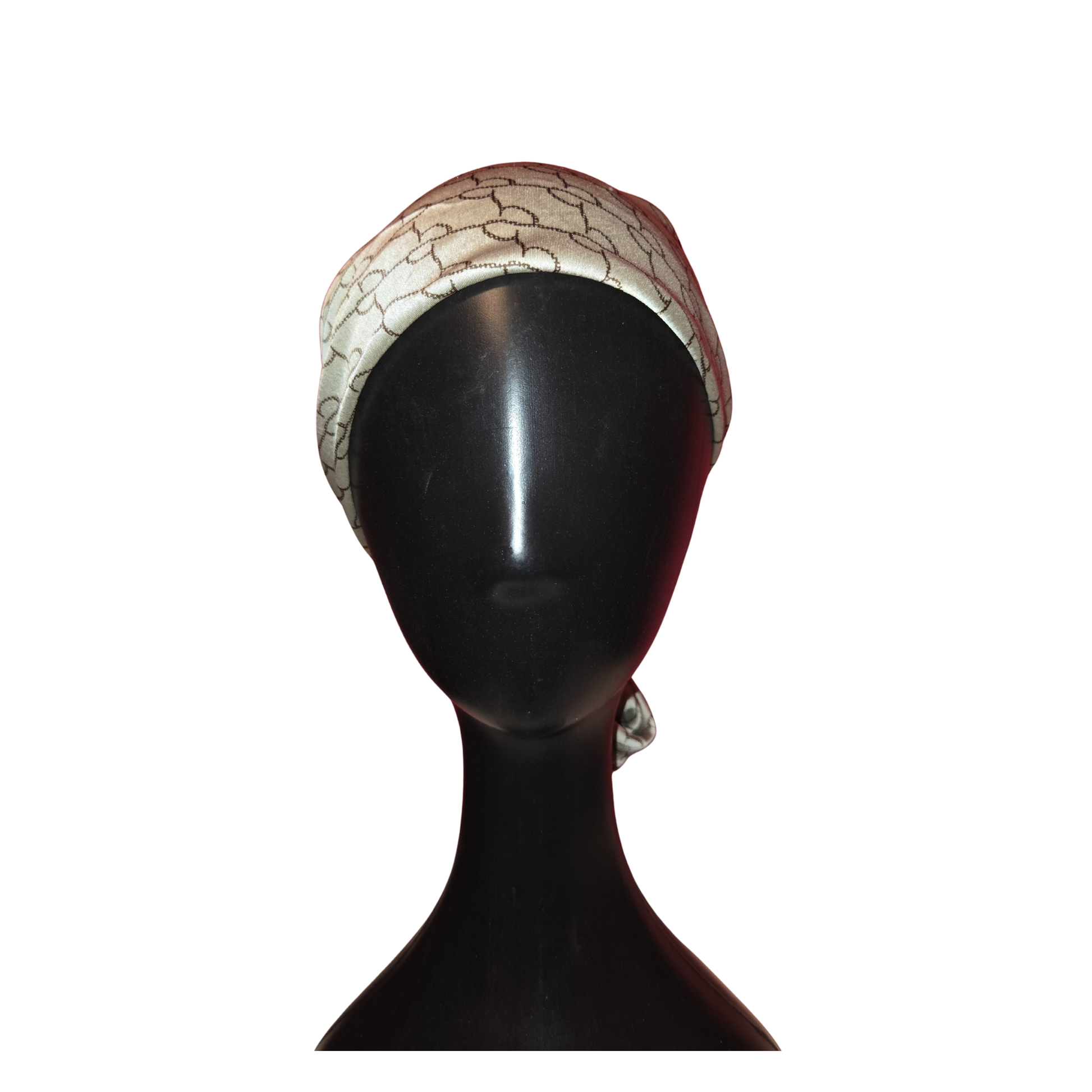 Mannequin head wearing a patterned headscarf on a white background