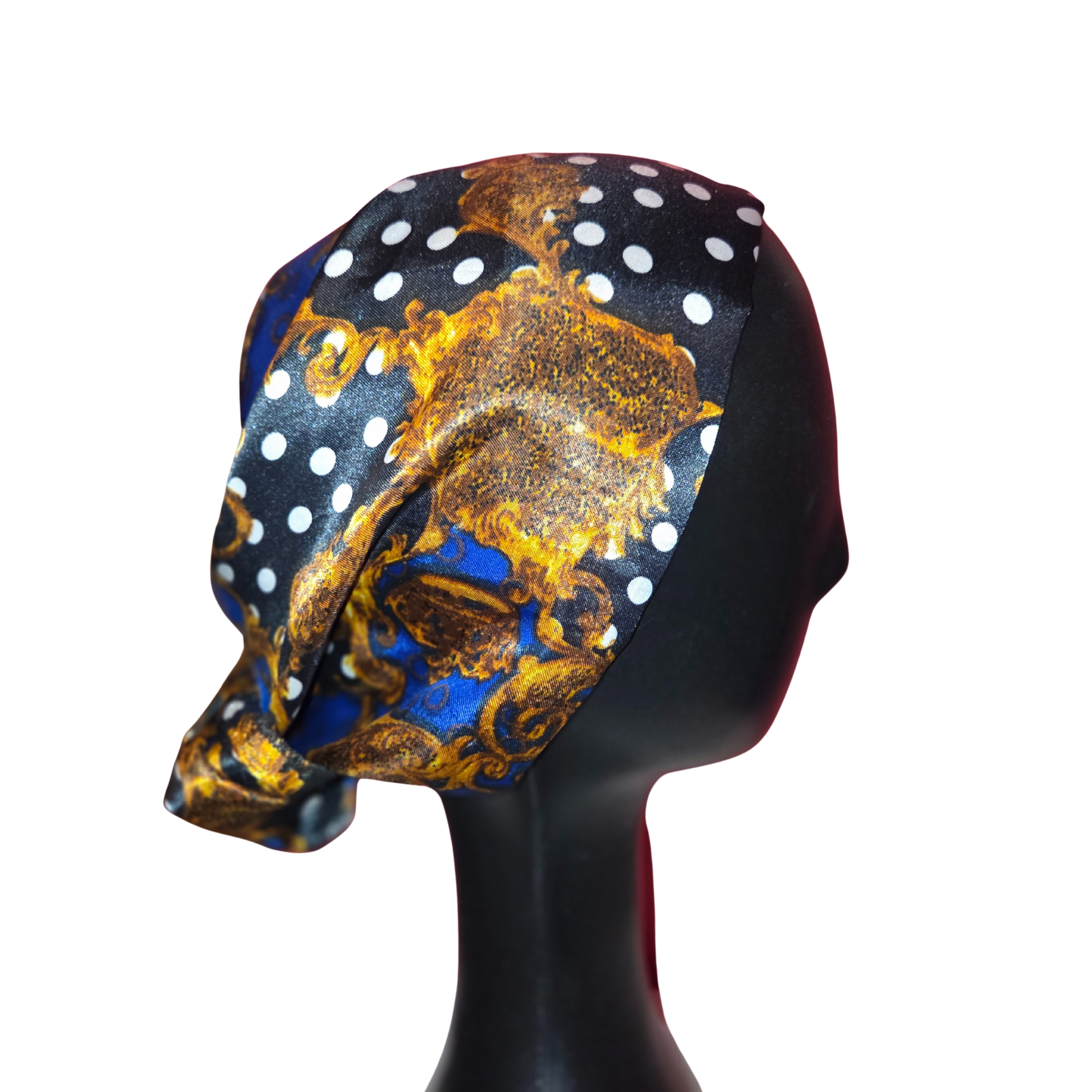 Headscarf with gold and blue design on a black mannequin head against a white background