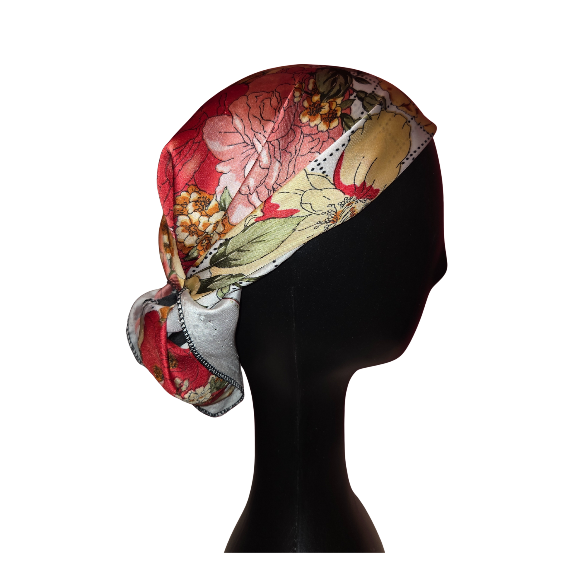 Colorful floral headscarf on a black mannequin head against a white background