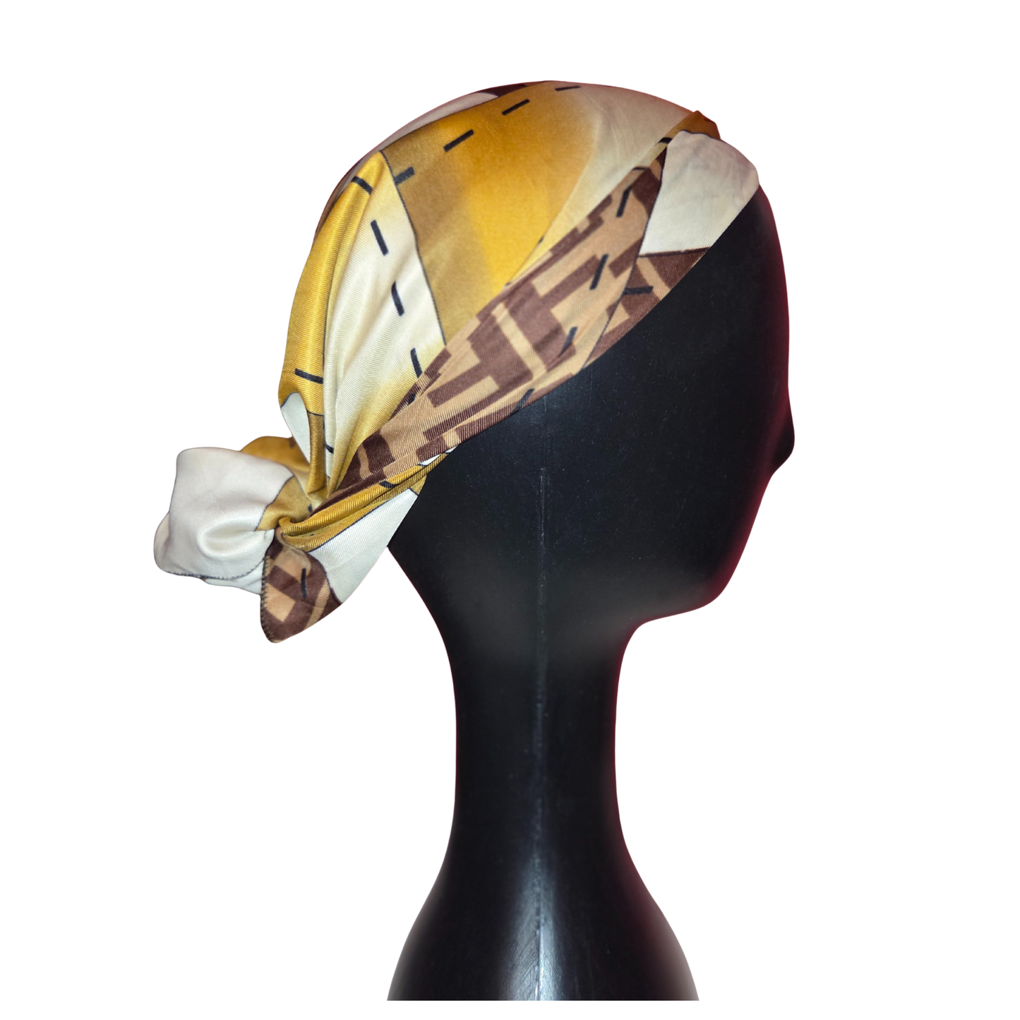 Mannequin head wearing a patterned headscarf with yellow, brown, and white colors on a white background.