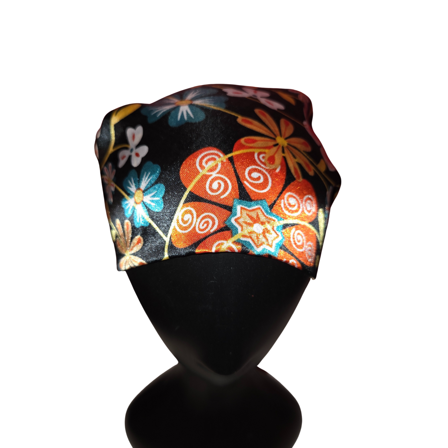 Colorful floral-patterned headscarf on a black mannequin head against a white background
