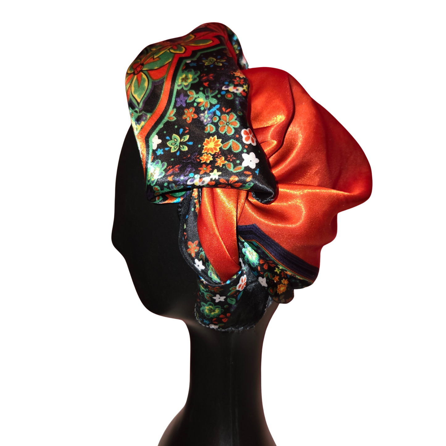 Colorful headscarf with floral patterns on a black mannequin head.