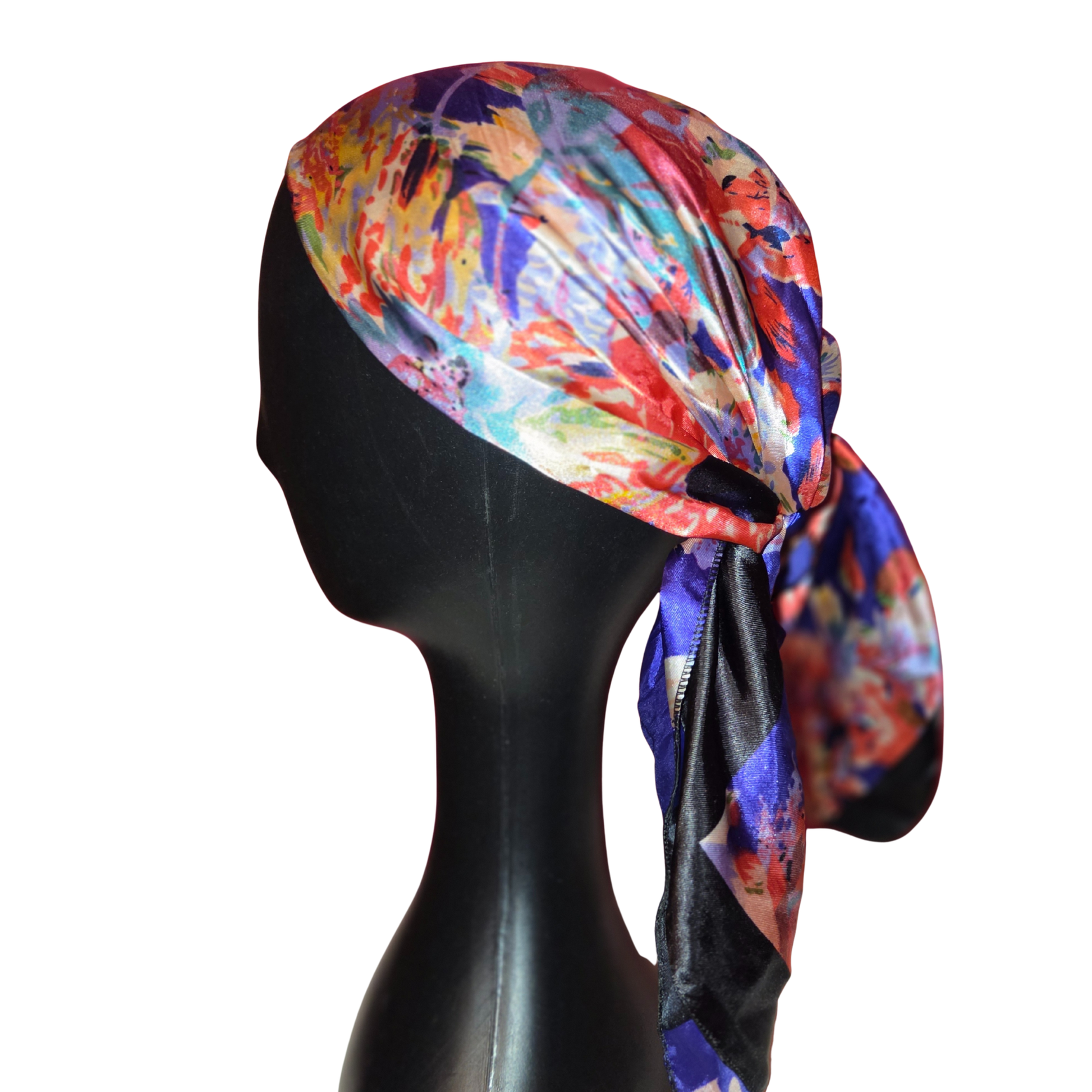 Colorful headscarf on a black mannequin head against a white background