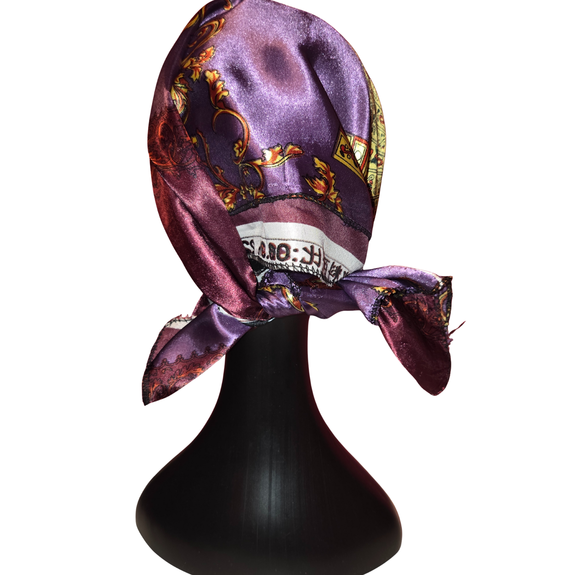 Purple patterned headscarf on a black mannequin head against a white background