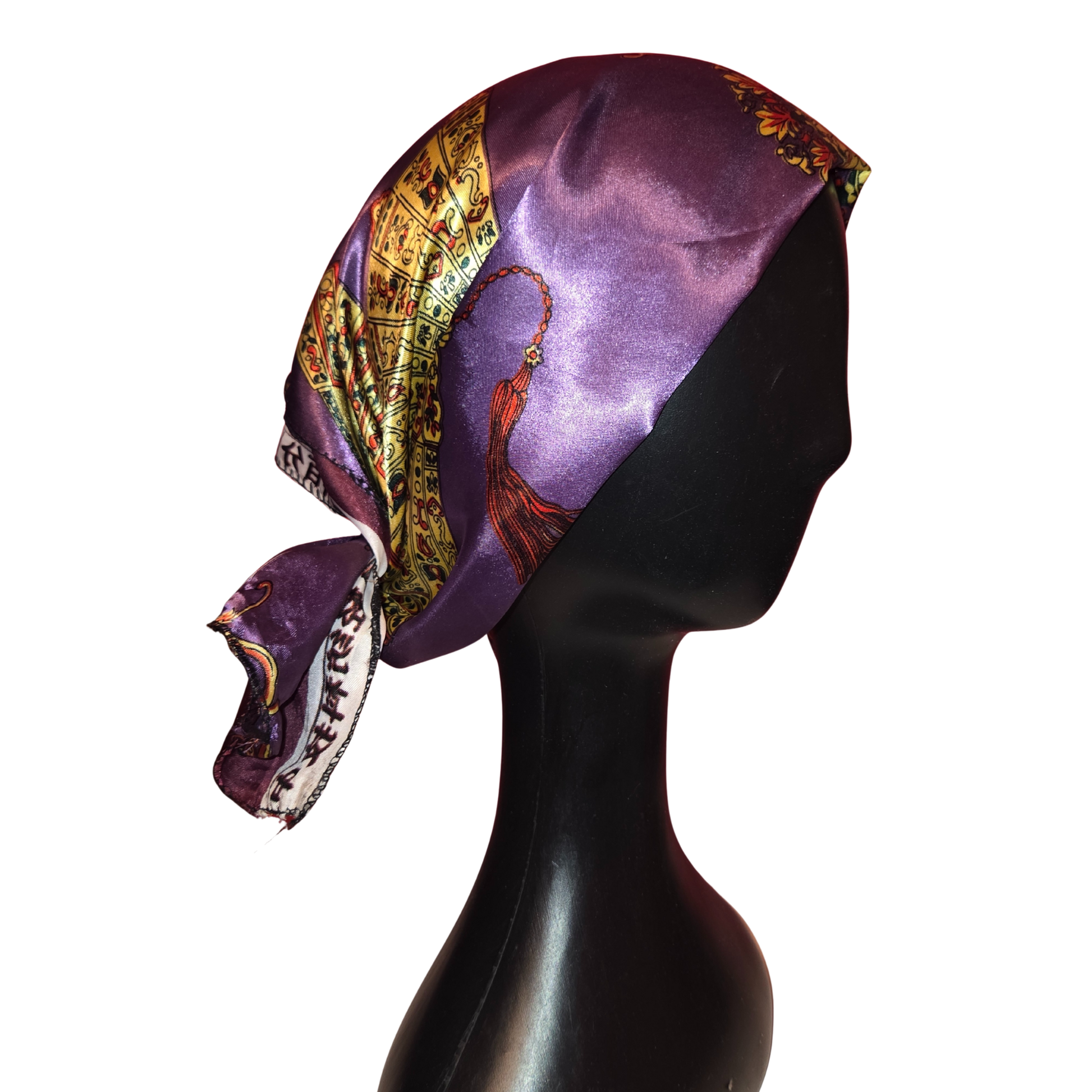 Mannequin head wearing a purple scarf with intricate patterns on a white background