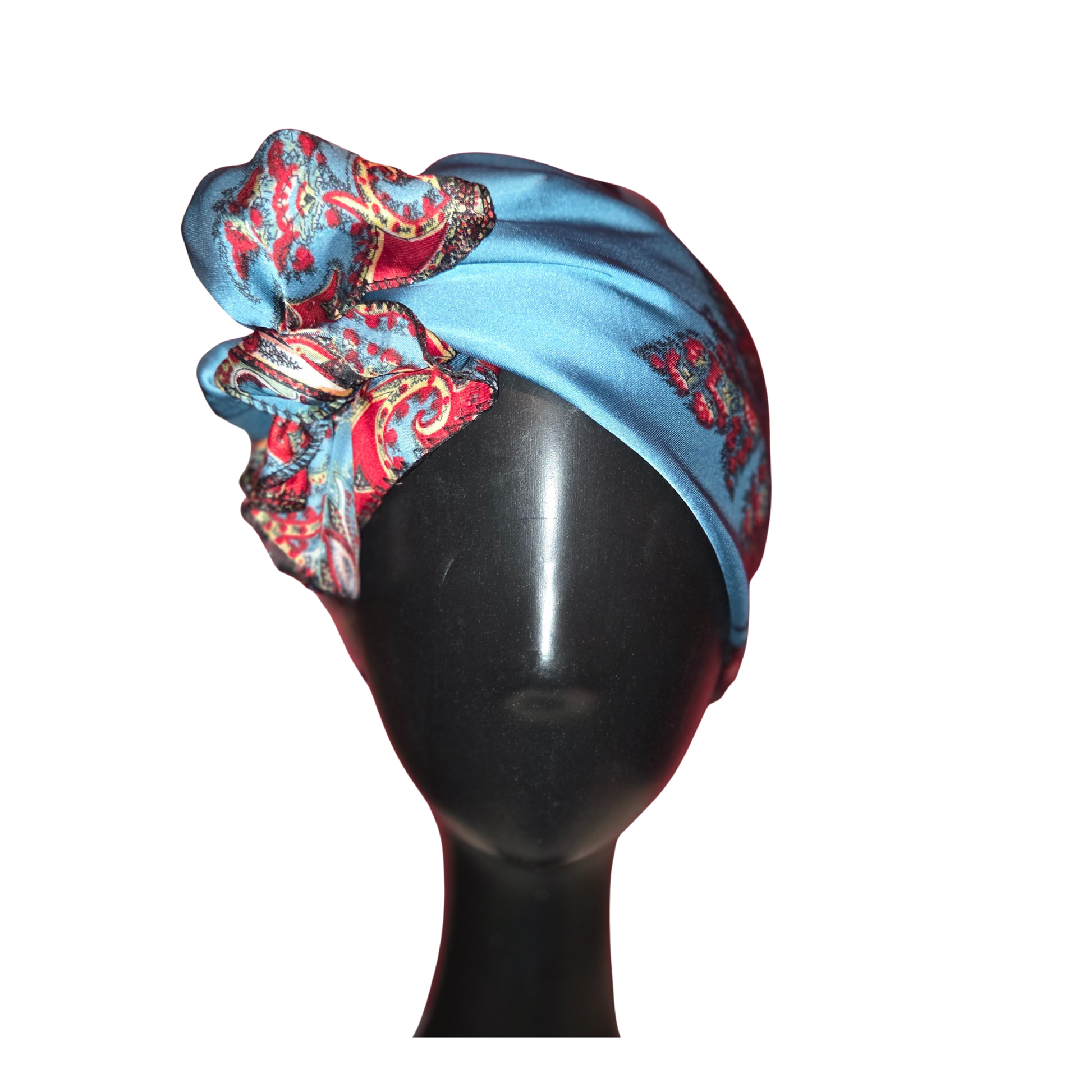 Blue headscarf with red and gold patterns on a black mannequin head against a white background