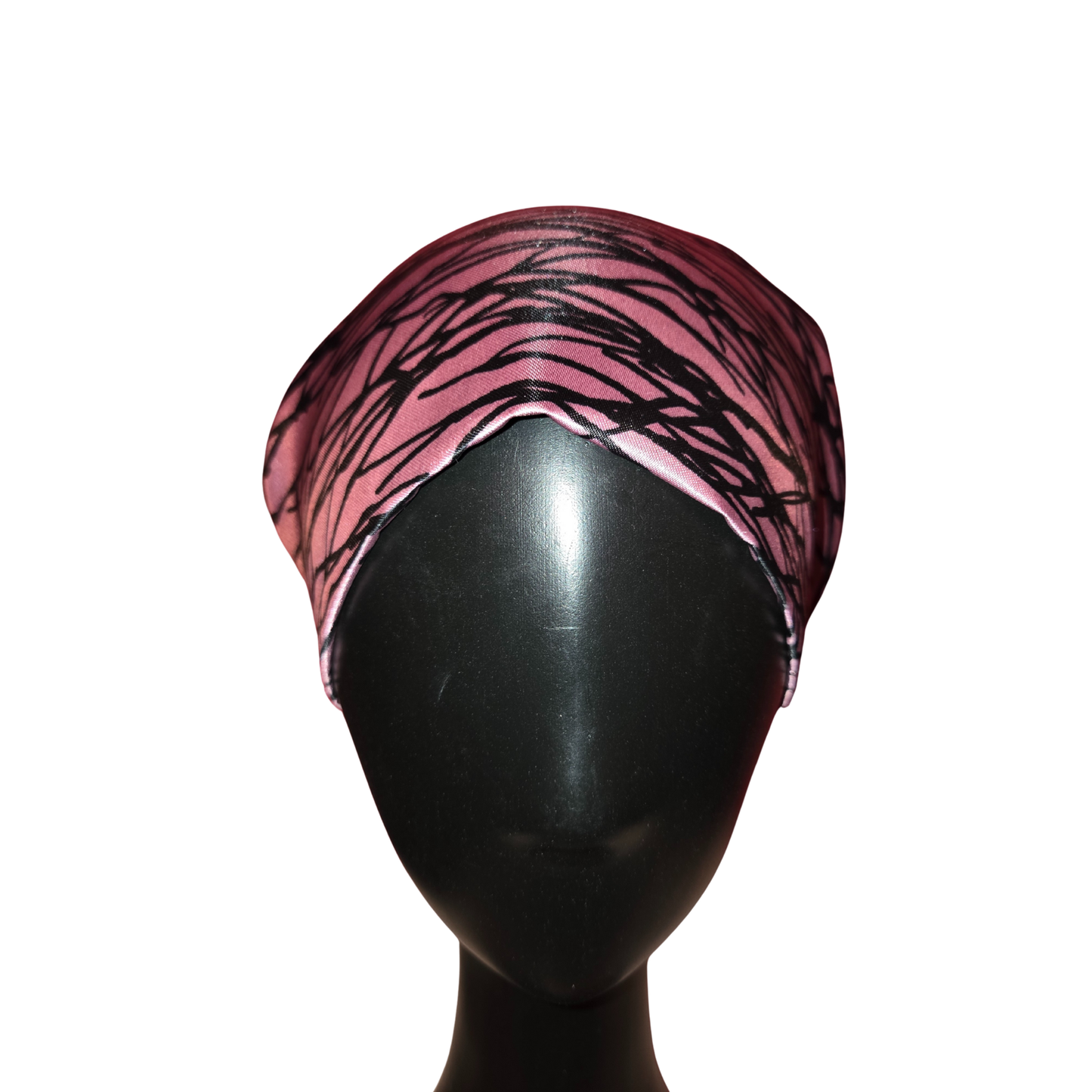 Pink and black patterned headscarf on a mannequin head against a white background